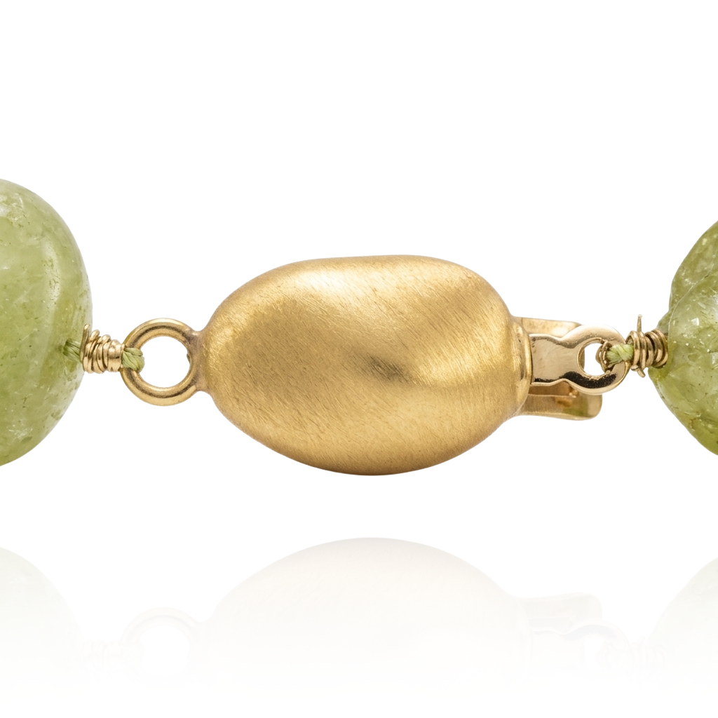 Collar gargantilla compuesto por peridoto verde vibrante. El broche y los detalles de formas irregulares con acabado mate están realizados en oro amarillo de 18 quilates.