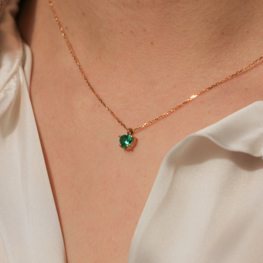 Collar realizado en oro amarillo de 18 quilates con un colgante de esmeralda con forma de corazón en cuatro garras