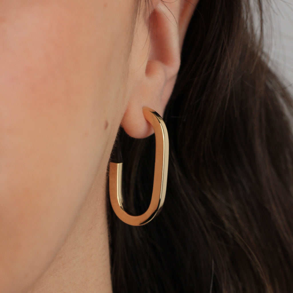 Pendientes estilo aro realizados en oro amarillo de 18 quilates con forma redonda alargada.