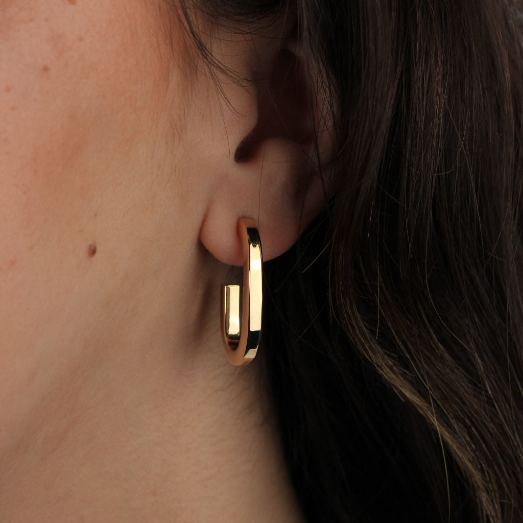 Pendientes estilo aro realizados en oro amarillo de 18 quilates con forma redonda alargada.