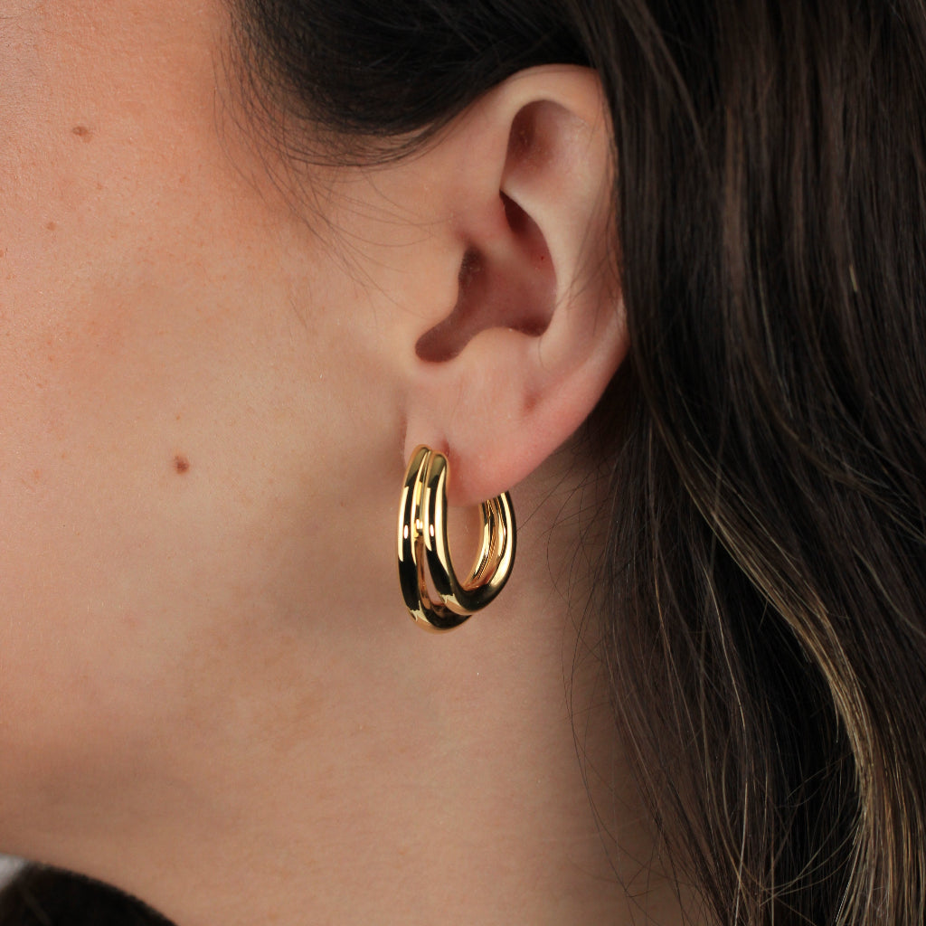 Pendientes de aro realizados en oro amarillo de 18 quilates en forma de doble tubo ovalado.