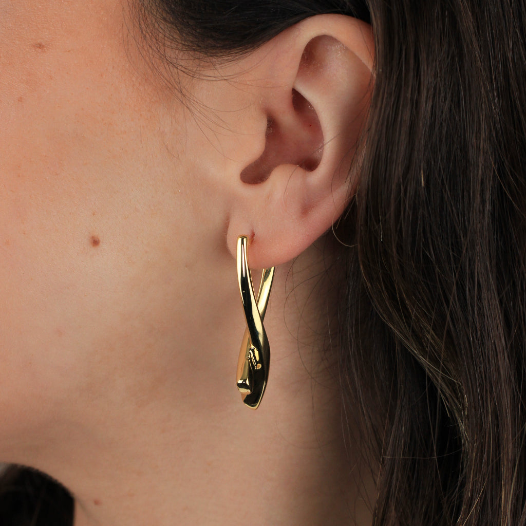 Pendientes realizados en oro amarillo de 18 quilates en forma de doble tubo cruzado en X.