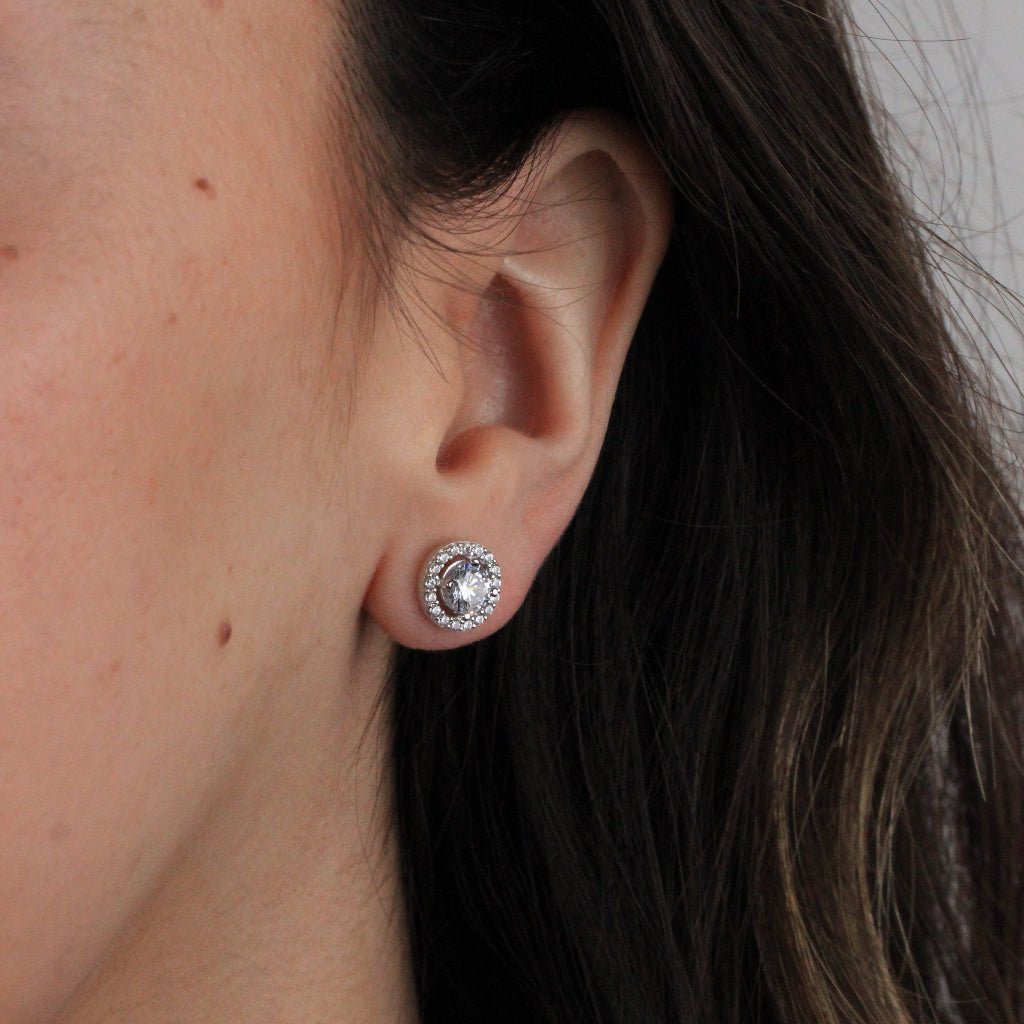 Pendientes de oro blanco de 18 quilates con un solitario de circonita central y una orla de circonitas.