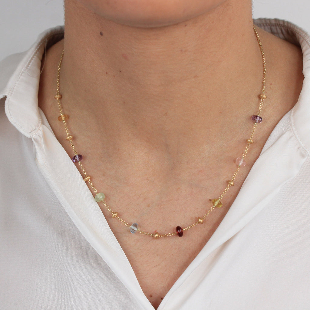 Gargantilla en oro amarillo de 18 quilates con piedras naturales en varios colores y motivos de oro matizados.