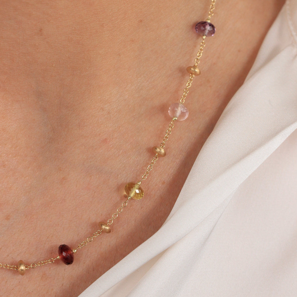 Gargantilla en oro amarillo de 18 quilates con piedras naturales en varios colores y motivos de oro matizados.