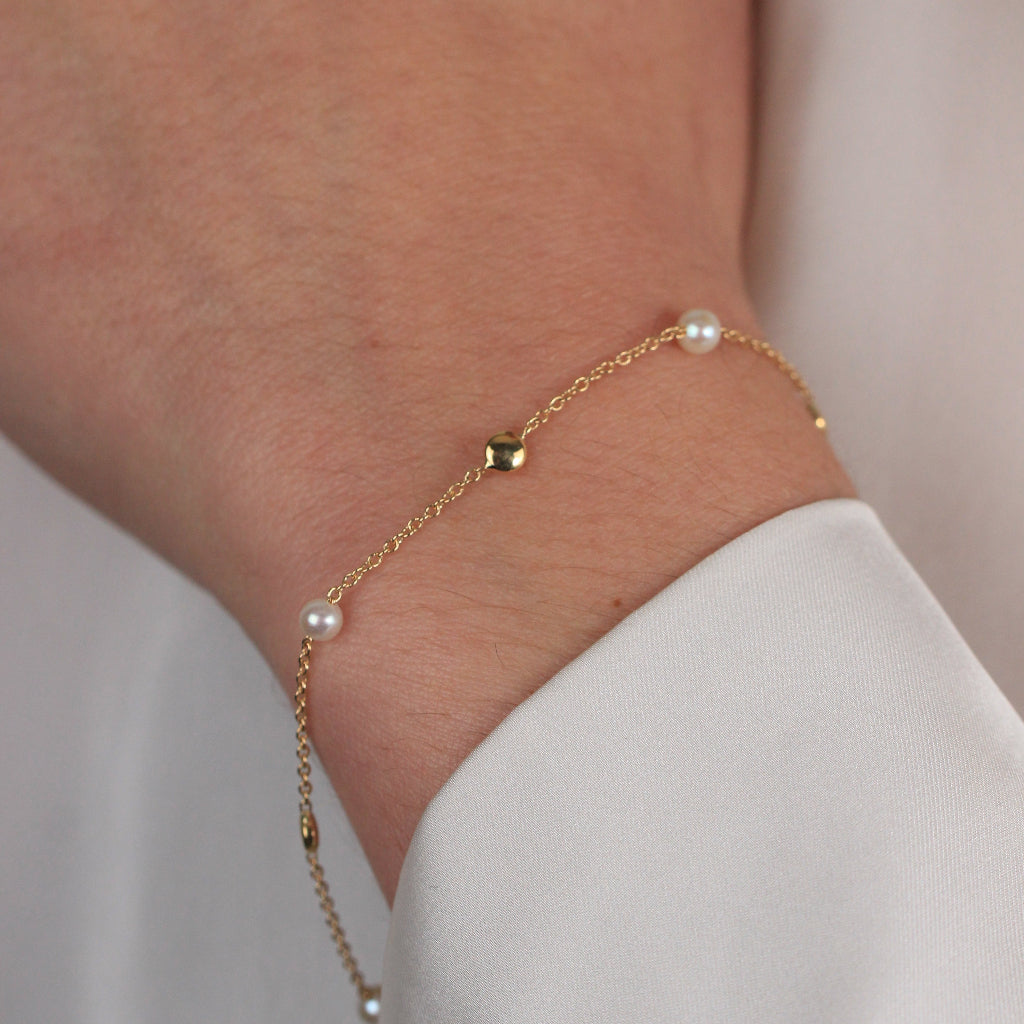 Pulsera realizada en oro amarillo de 18 quilates con motivos circulares lisos y perlas cultivadas