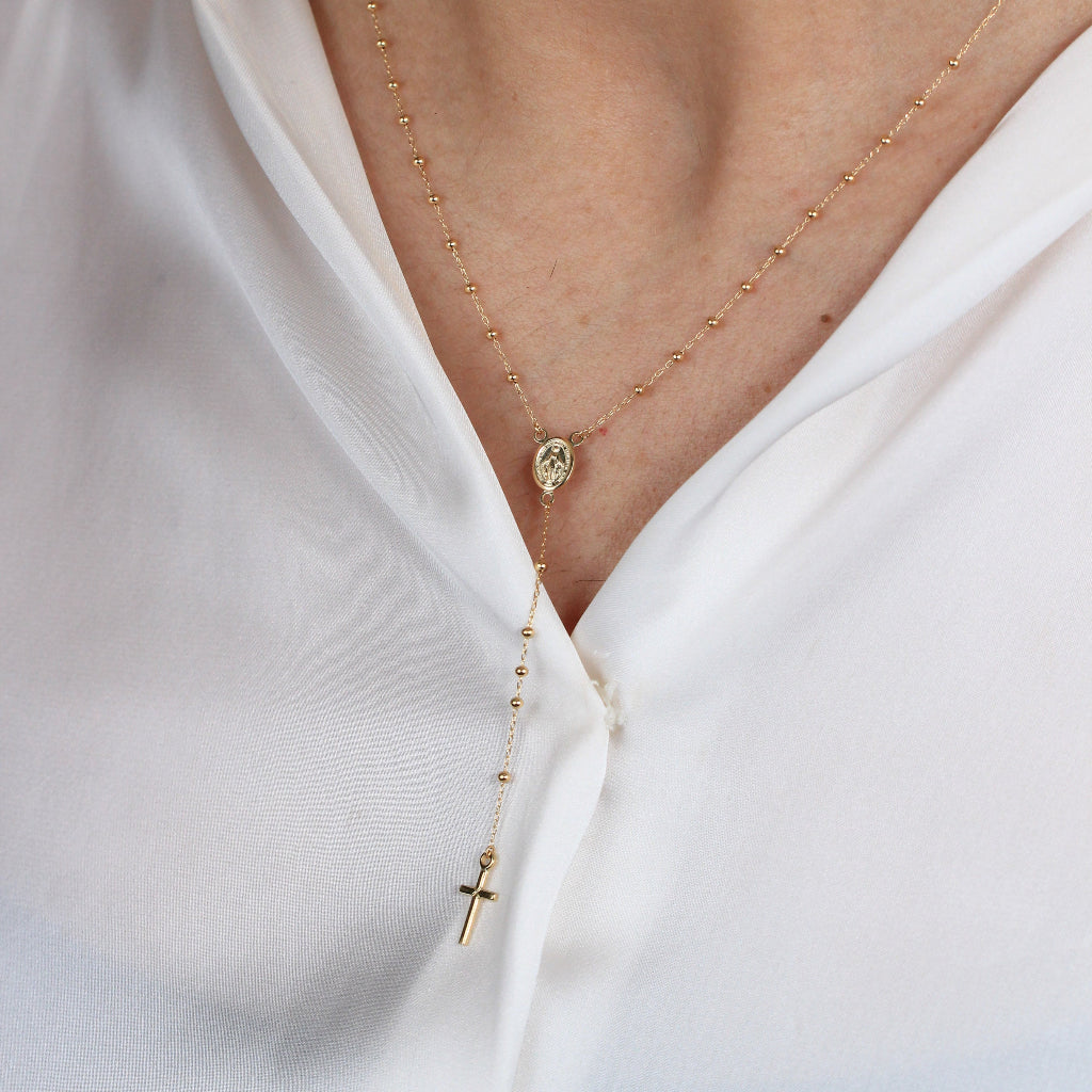 Collar rosario en oro amarillo de 18 quilates con varios motivos esféricos, una cruz y la virgen de la milagrosa.