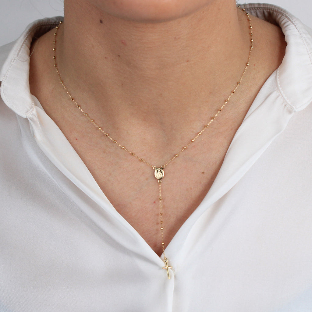 Collar rosario en oro amarillo de 18 quilates con varios motivos esféricos, una cruz y la virgen de la milagrosa.