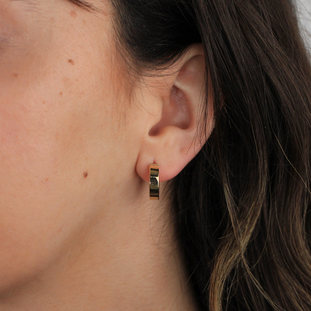 Pendientes de aro en oro amarillo de 18 quilates liso con forma aplanada.