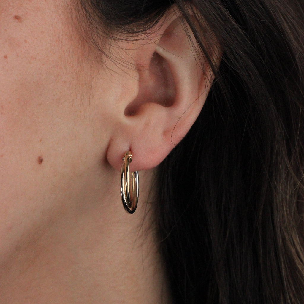 Pendientes de aro en oro blanco y amarillo de 18 quilates. El aro es doble con forma ovalada.