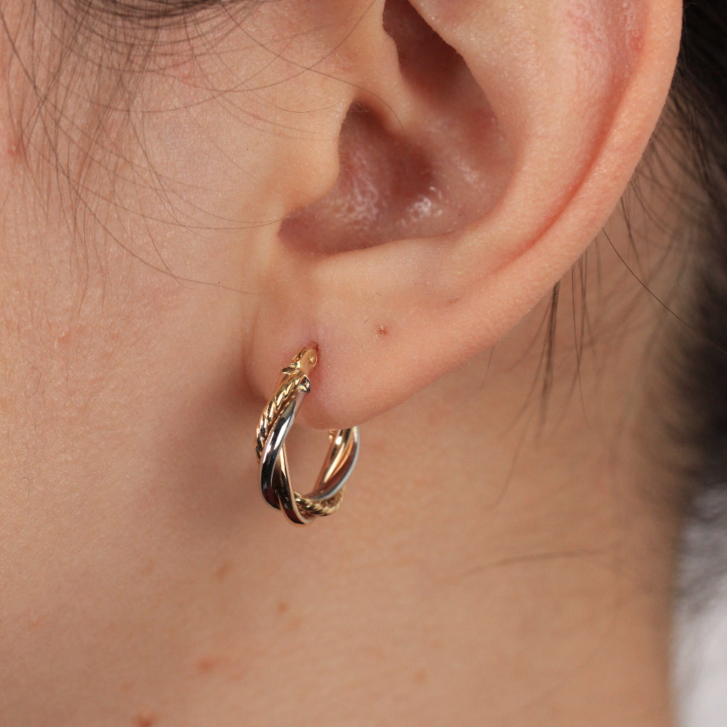 Pendientes de aro tricolor en oro blanco, rosa y amarillo de 18 quilates con tres brazos entrelazados.