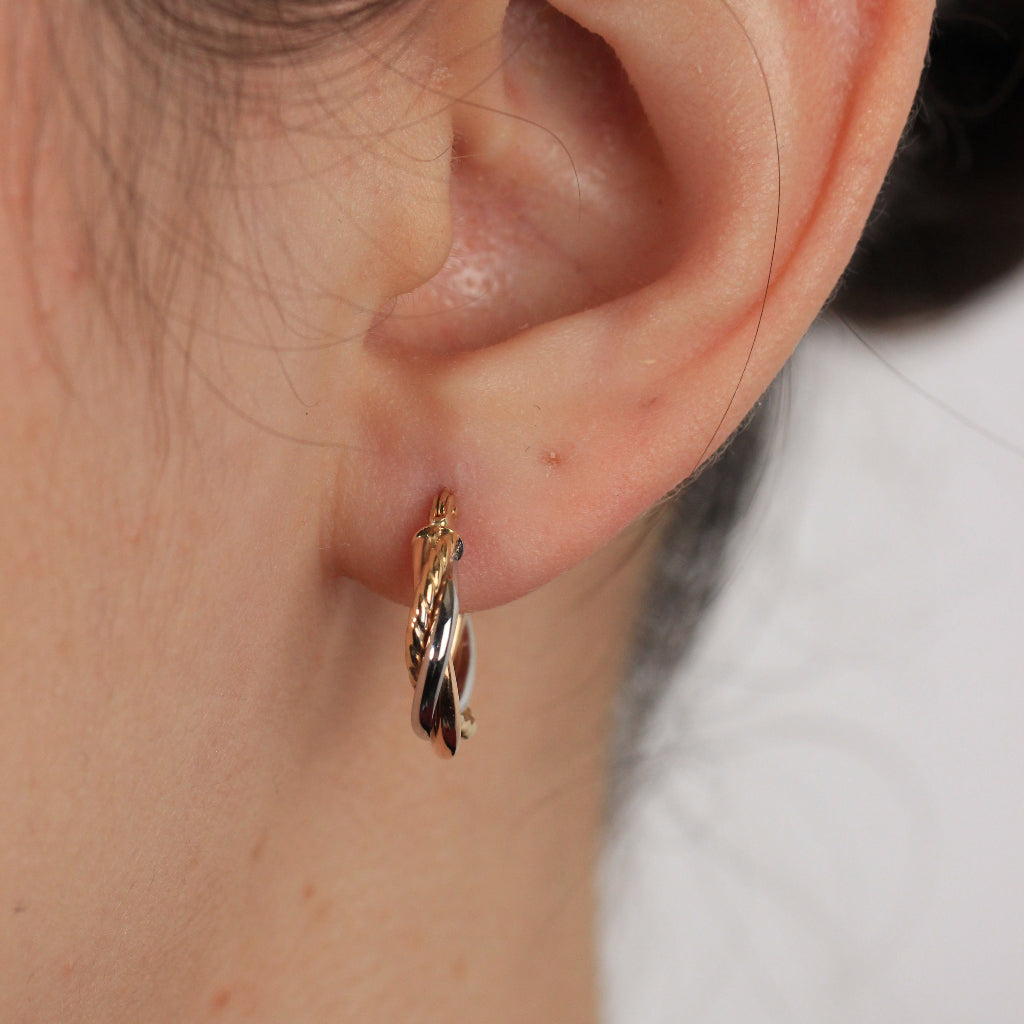 Pendientes de aro tricolor en oro blanco, rosa y amarillo de 18 quilates con tres brazos entrelazados.