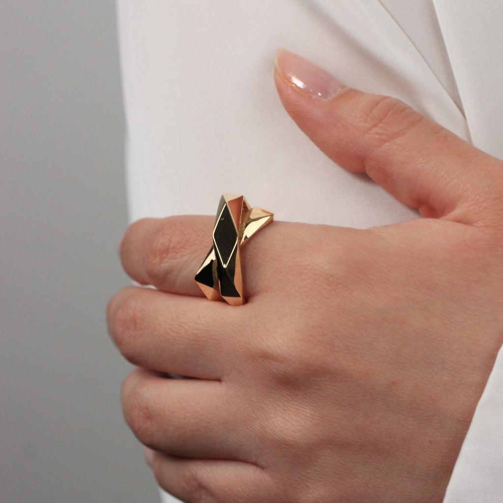 Sortija de oro amarillo de 18kt con dos brazos lisos facetados cruzados.