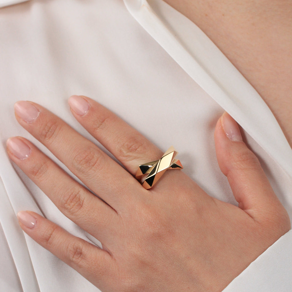 Sortija de oro amarillo de 18kt con dos brazos lisos facetados cruzados.