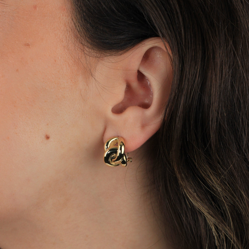 Pendientes en realizados oro amarillo de 18 quilates con dos aros enlazados en forma de ocho. Sistema de cierre omega.