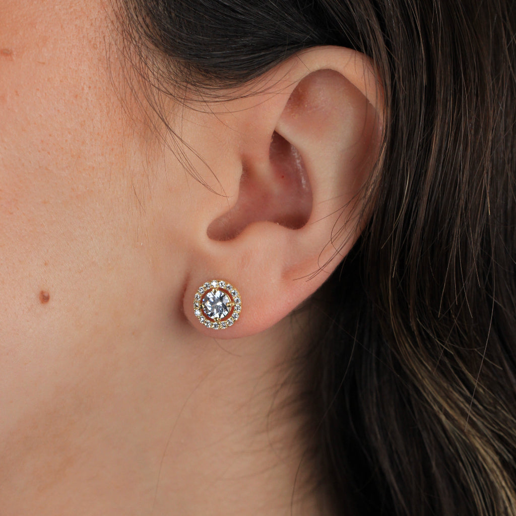 Pendientes realizados en oro amarillo de 18 quilates con una circonita central y una orla de circonitas.