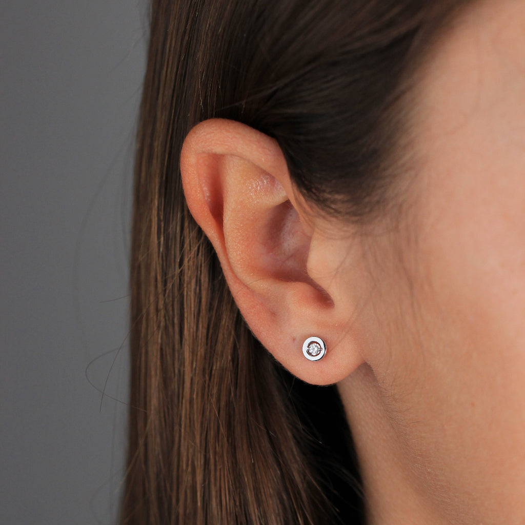 Pendientes pequeños de oro blanco de 18k con un diamante central