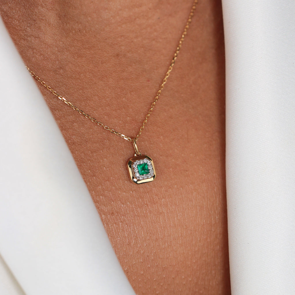 Collar de oro amarillo de 18k con una esmeralda central u orla de diamantes