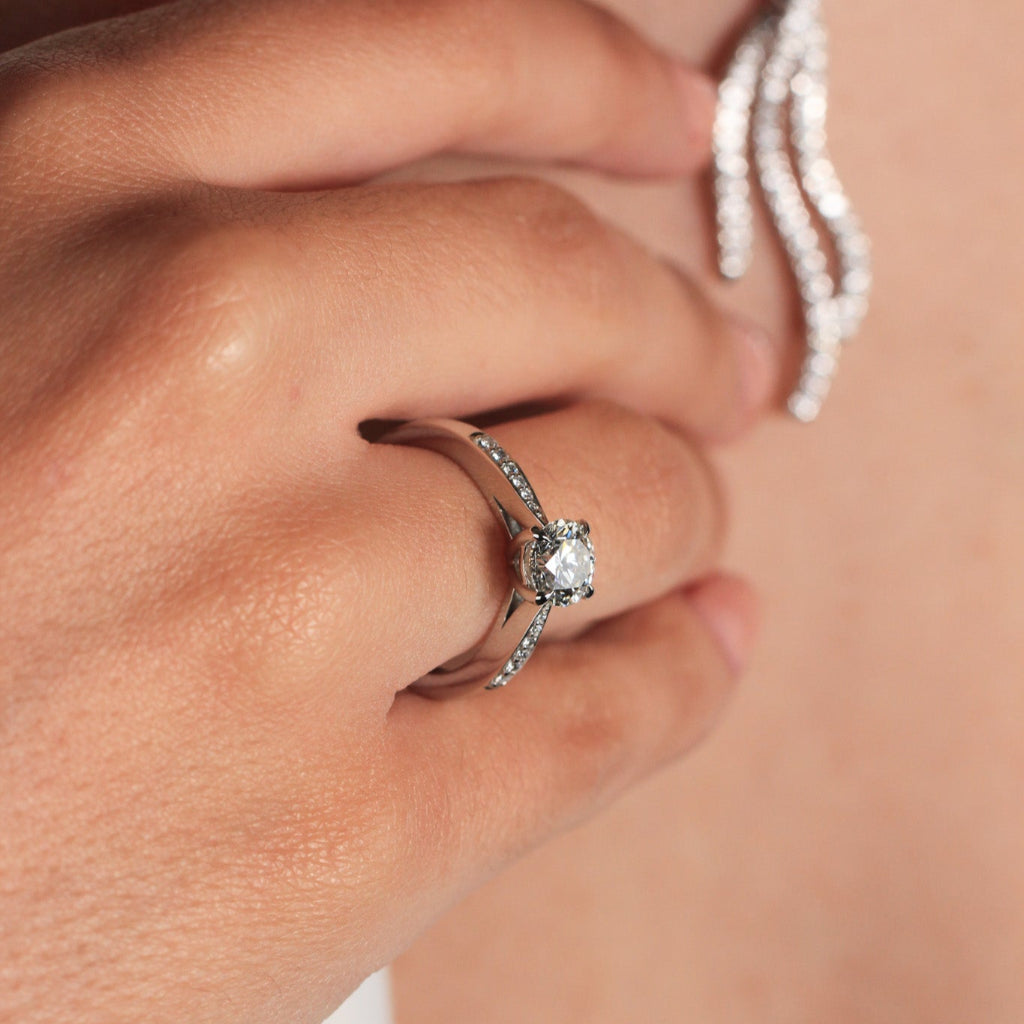 Sortija realizada en platino 960 con un diamante central talla brillante y 12 diamantes en los laterales. Joyería Pamplona