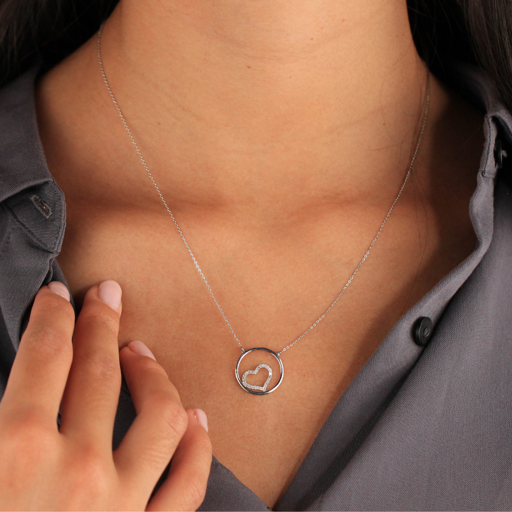Gargantilla realizada en oro blanco de 18 quilates con un diseño de aro calado que enmarca un corazón pavonado de diamantes con un peso total de 0,14cts.