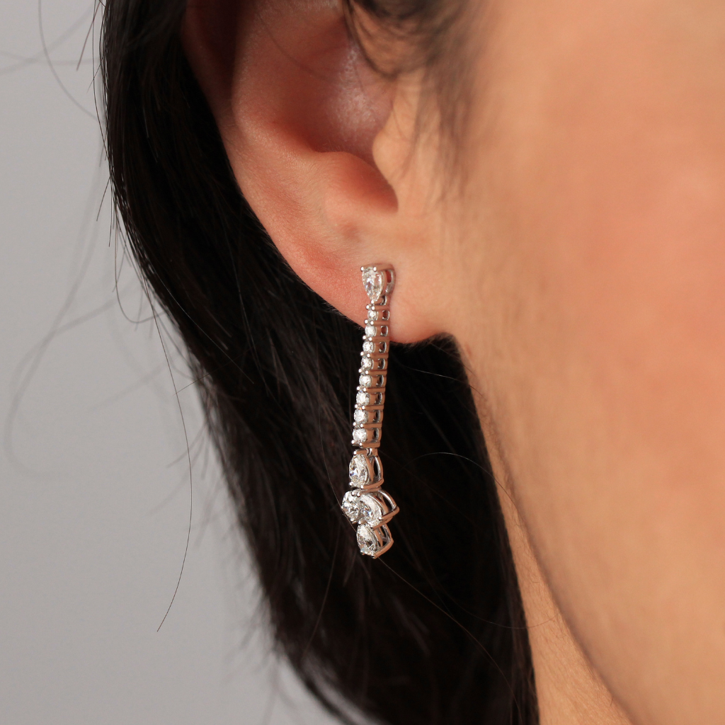 Pendientes tipo caída rivière realizados en oro blanco de 18 quilates con 16 diamantes naturales talla brillante y 10 diamantes naturales talla pera.