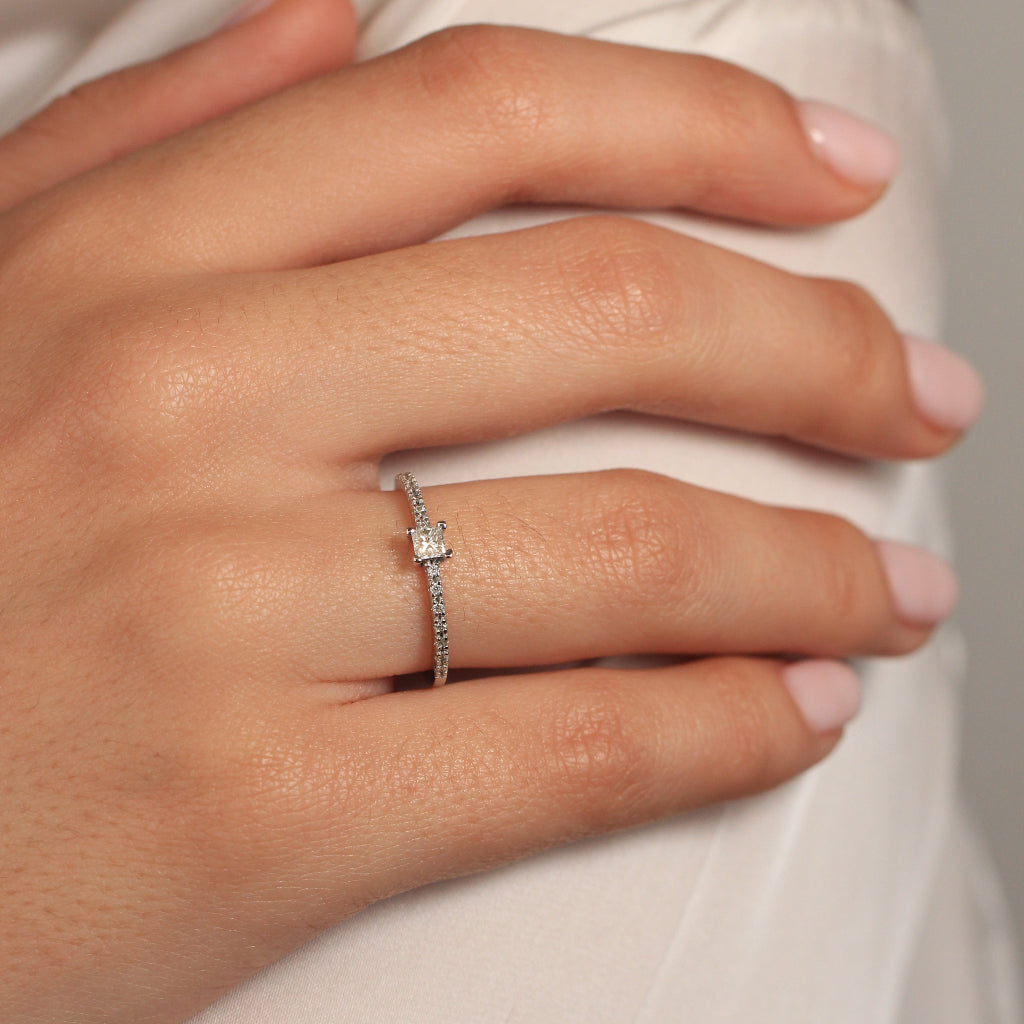 Sortija de compromiso con diamante talla princesa y laterales