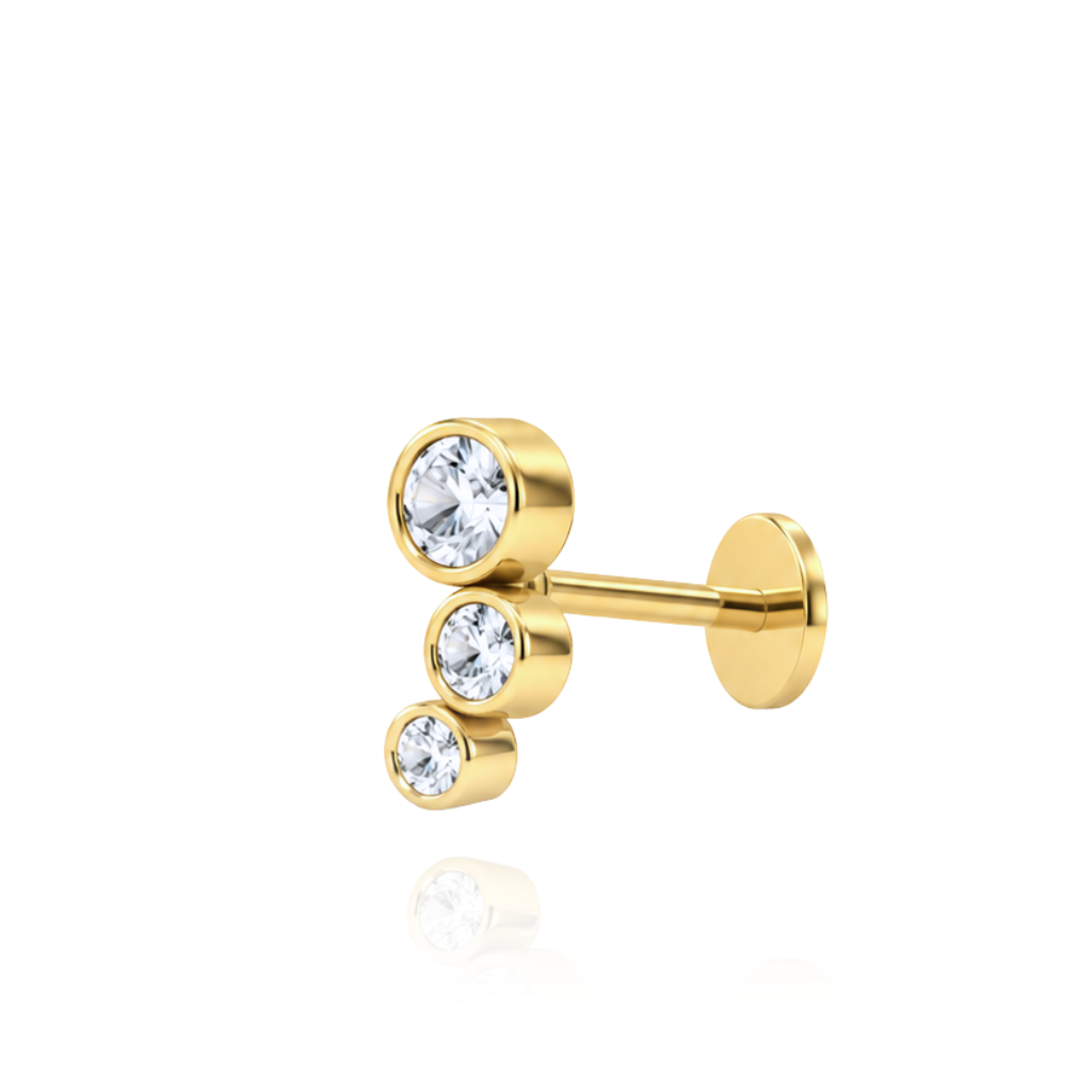 Piercing realizado en oro de 18 quilates con tres circonitas.