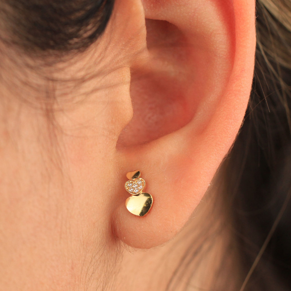 Pendientes de oro amarillo de 18 quilates con doble motivo corazón y circonitas.