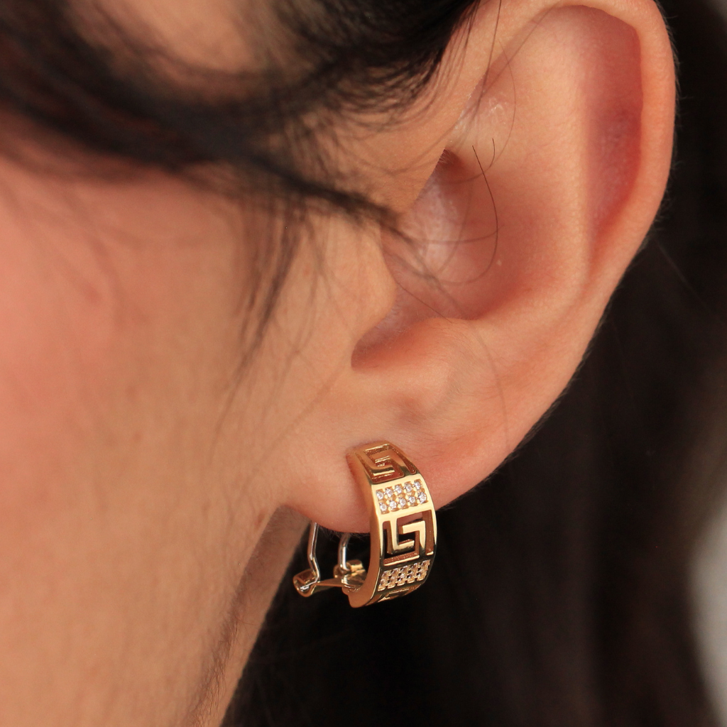 Pendientes realizados en oro amarillo de 18 quilates tipo aro con motivo greca y circonitas.