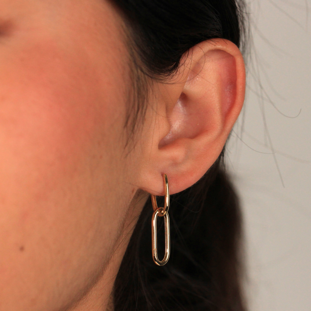 Pendientes realizados en oro amarillo de 18 quilates tipo aro con colgante de eslabón ovalado.
