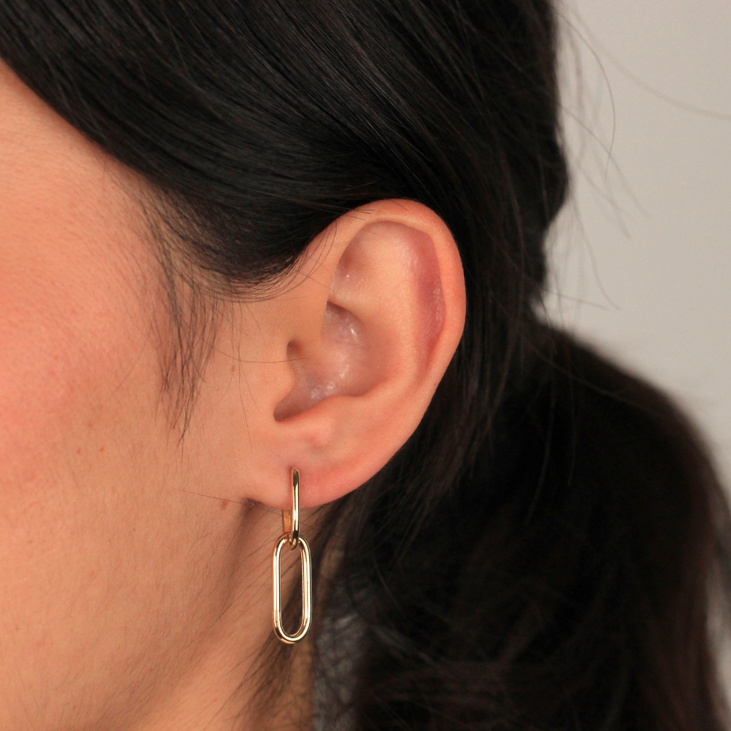 Pendientes realizados en oro amarillo de 18 quilates tipo aro con colgante de eslabón ovalado.