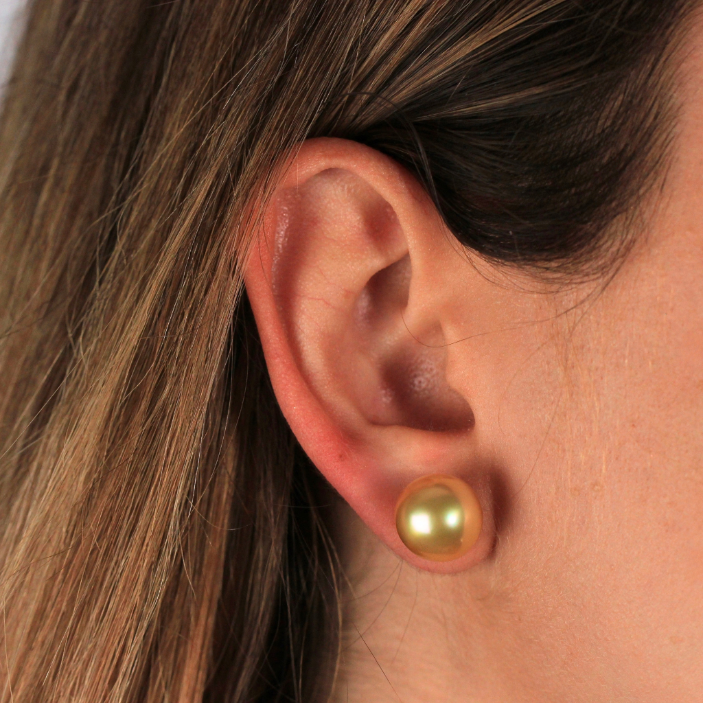 Pendientes de perla Golden con pernio en oro amarillo y presión en oro blanco de 18 kt.