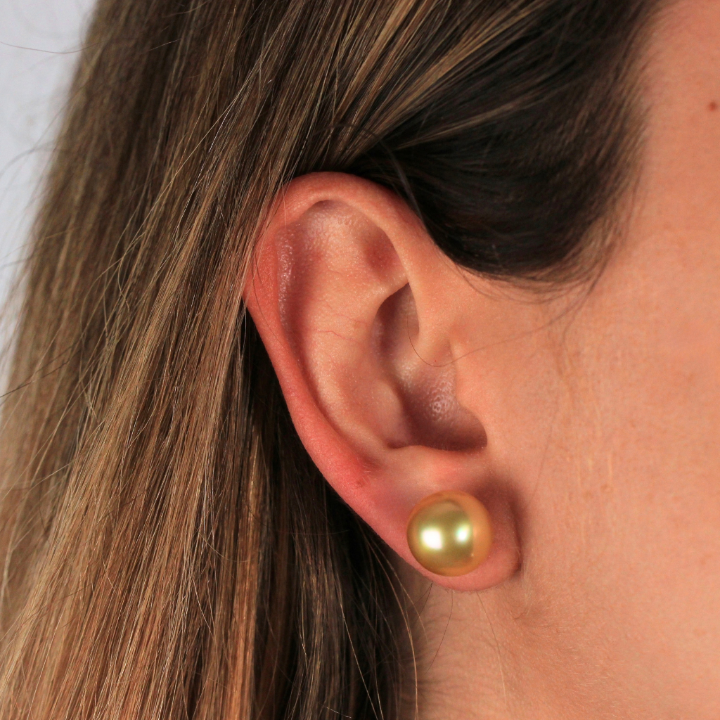 Pendientes de perla Golden con pernio en oro amarillo y presión en oro blanco de 18 kt.