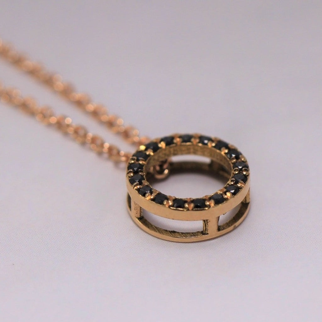 Colgante de oro rosa de 18 quilates circular cuajado de diamantes negros talla brillante. Joyería Pamplona.