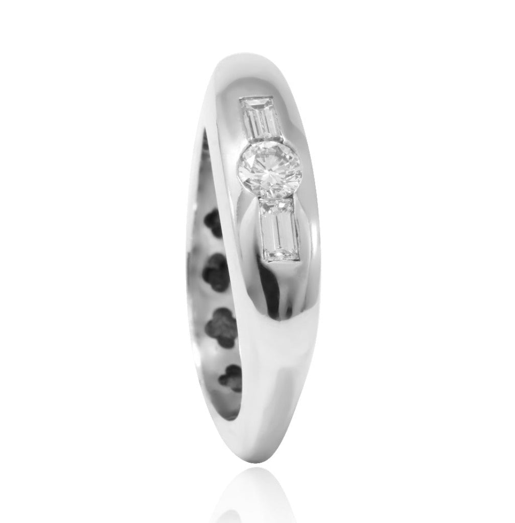 Sortija realizada en oro blanco de 18 quilates con un diamante central talla brillante y dos diamantes talla baguette a cada lado.
