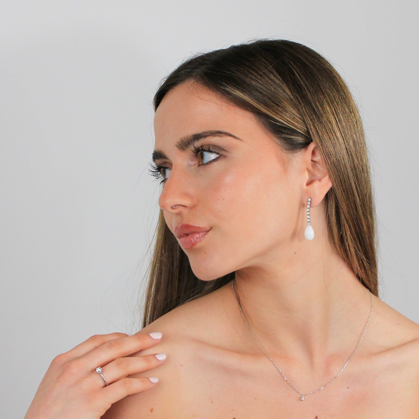 Modelo con pendientes largos de coral blanco y diamantes en bruto