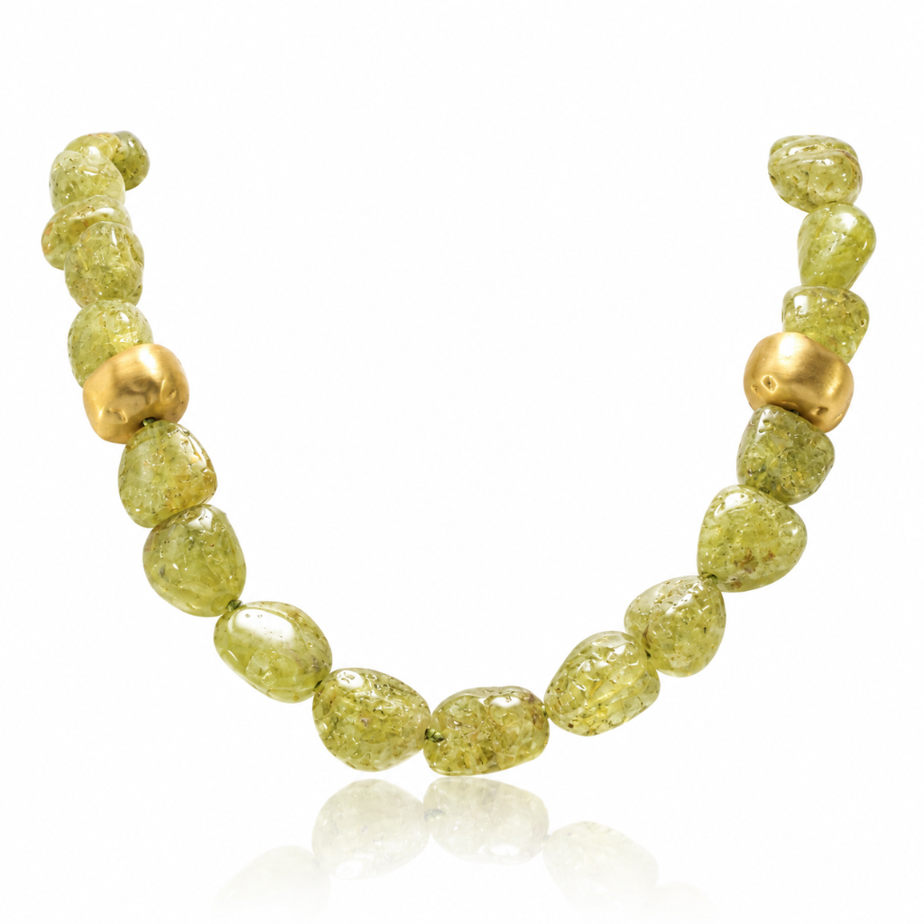 Collar gargantilla compuesto por peridoto verde vibrante. El broche y los detalles de formas irregulares con acabado mate están realizados en oro amarillo de 18 quilates.