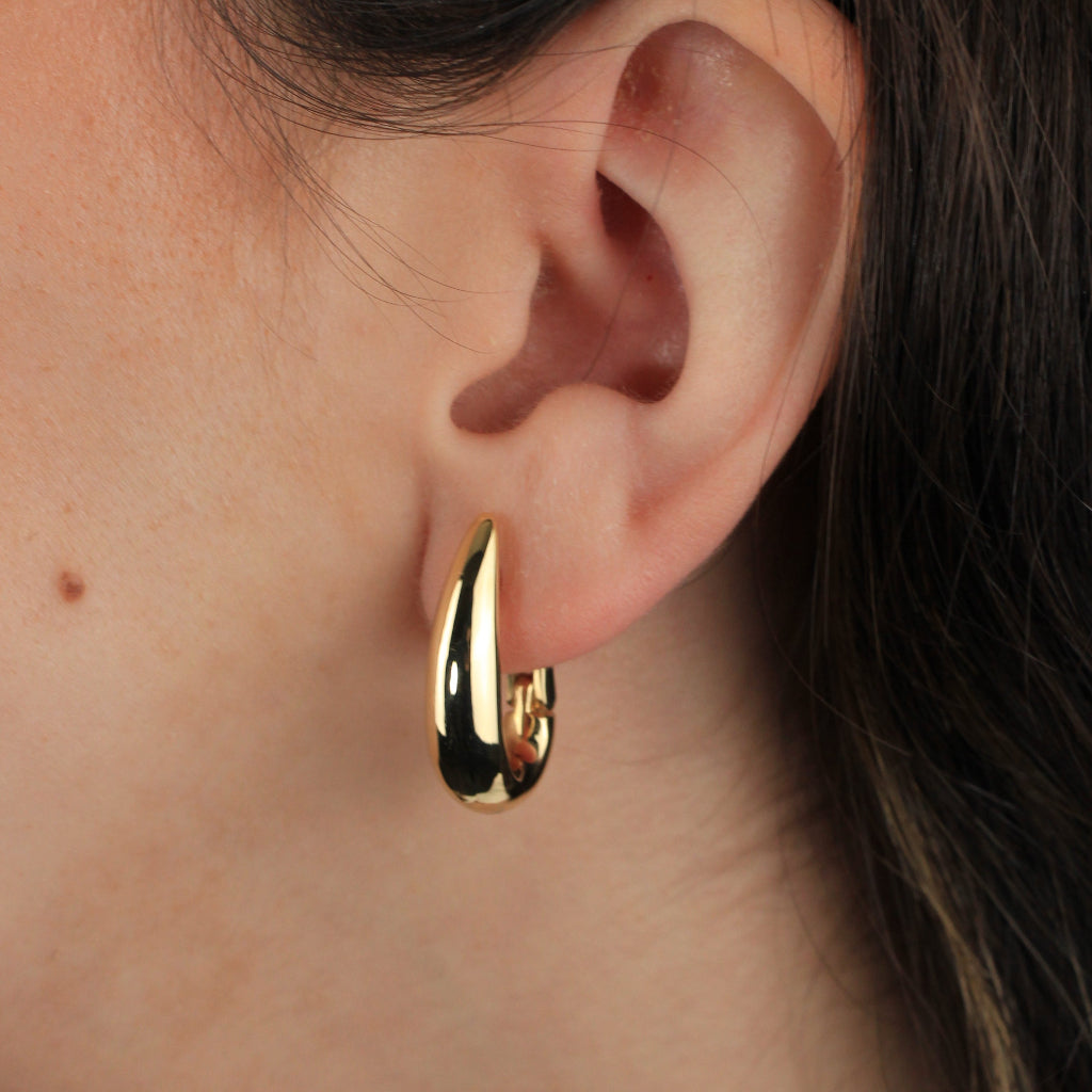 Pendientes estilo aro realizados en oro amarillo de 18 quilates con forma ovalada abombados. 