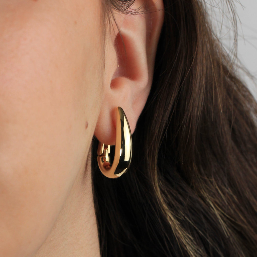 Pendientes estilo aro realizados en oro amarillo de 18 quilates con forma ovalada abombados. 