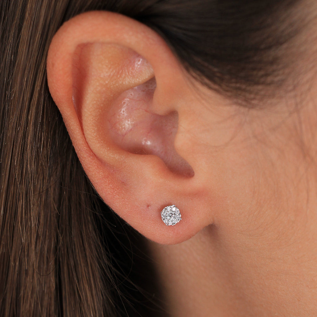 Pendientes pequeños de oro blanco con un diamante central y orla de diamantes