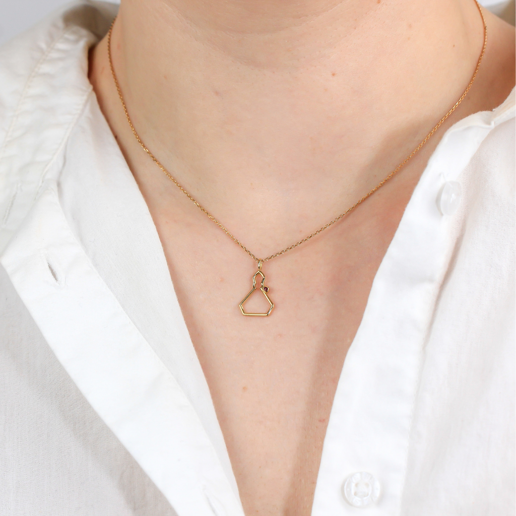 Collar realizado en oro amarillo de 18 quilates con la silueta de San Fermín en liso y un rubí