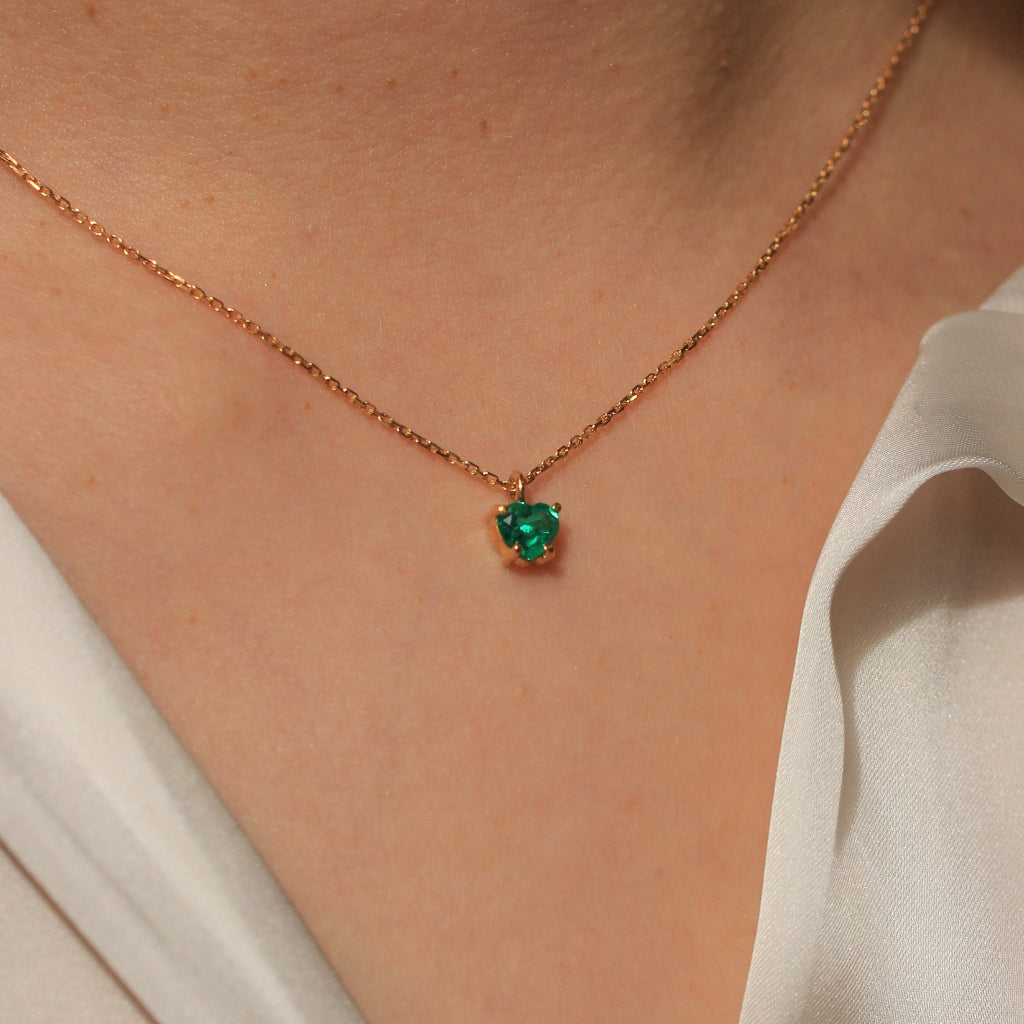 Collar realizado en oro amarillo de 18 quilates con un colgante de esmeralda con forma de corazón en cuatro garras