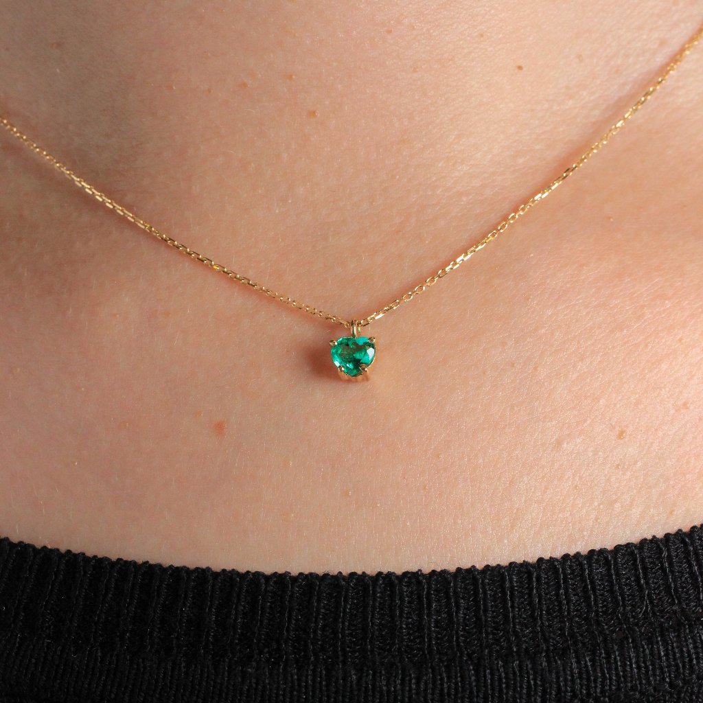 Collar realizado en oro amarillo de 18 quilates con un colgante de esmeralda con forma de corazón en cuatro garras