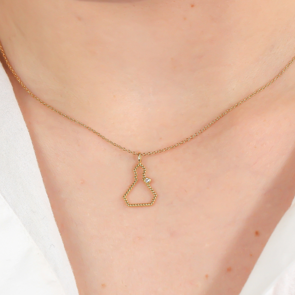 Collar realizado en oro amarillo de 18 quilates con la silueta de San Fermín en hilo de bolitas y un diamante talla brillante