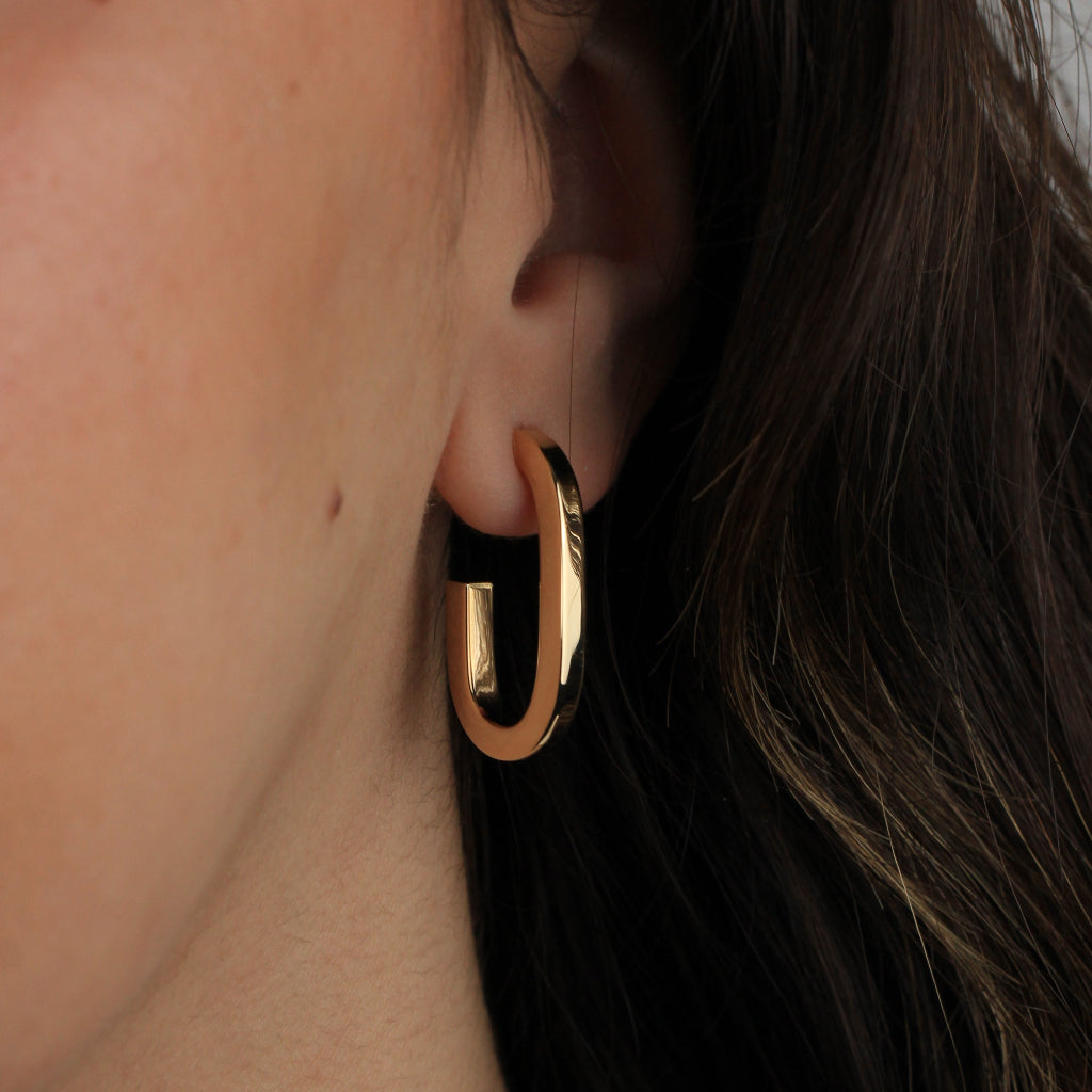 Pendientes estilo aro realizados en oro amarillo de 18 quilates con forma redonda alargada.