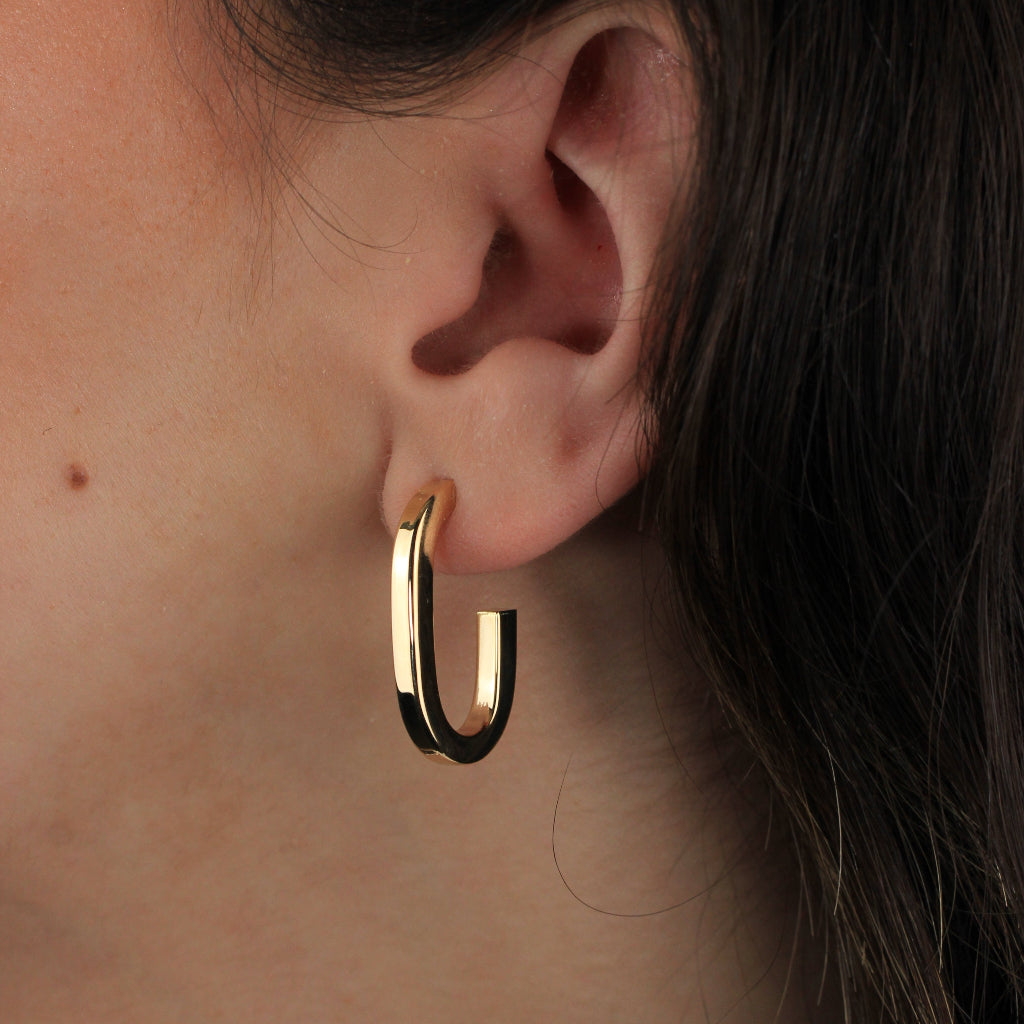 Pendientes estilo aro realizados en oro amarillo de 18 quilates con forma redonda alargada.