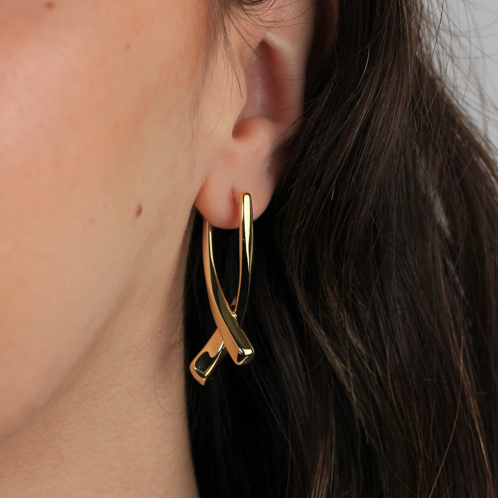 Pendientes realizados en oro amarillo de 18 quilates en forma de doble tubo cruzado en X.