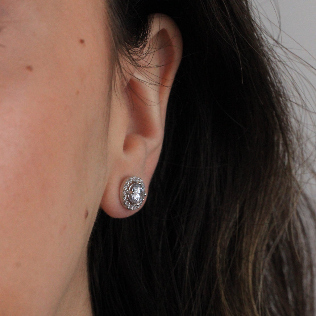 Pendientes de oro blanco de 18 quilates con un solitario de circonita central y una orla de circonitas.