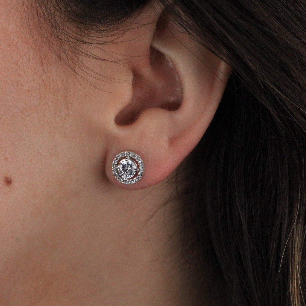 Pendientes de oro blanco de 18 quilates con un solitario de circonita central y una orla de circonitas.