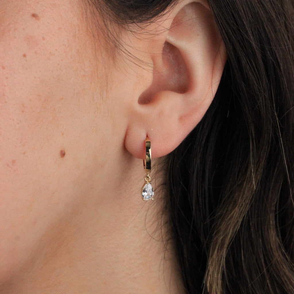 Pendientes de aro en oro amarillo de 18 quilates liso con forma aplanada y un colgante de circonita en forma de lágrima.